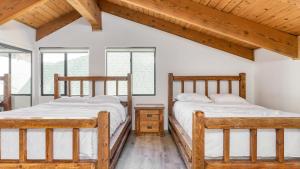 2 Betten in einem Zimmer mit Holzdecken und Fenstern in der Unterkunft Honeypot by AvantStay Indoor Pool Hot Tub in Big Bear Lake + 22 Fotos
