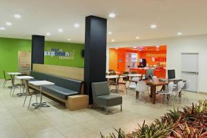 a dining area with tables and chairs in a restaurant at One Queretaro Aeropuerto in Querétaro