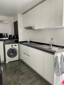 a kitchen with a sink and a washing machine at Extra large, modern apartment with sea view in Bang Rak Beach