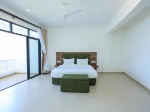 a white bedroom with a bed and a chair at Baobab Waves in Mombasa +21 photos
