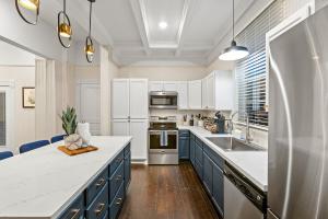 een keuken met witte apparatuur en blauwe kasten bij Beach House Fun! Sleeps the Whole Crew in Galveston