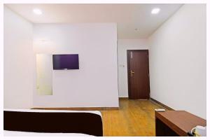 a white room with a bed and a door at Hotel BNK Residency Near Temple and Railway Station in Ujjain