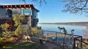 ein Haus am Ufer eines Sees mit einer Bank in der Unterkunft Langley Waterfront Condo by AvantStay A Views in Langley
