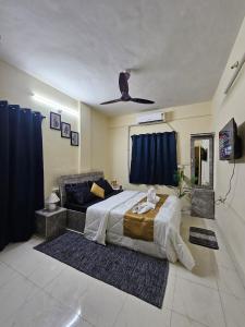 Un dormitorio con una cama y un ventilador de techo. en Solitude Stays, en Pune