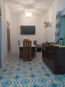una sala da pranzo con un tavolo e una TV a parete di U-trn home stay a Bikaner