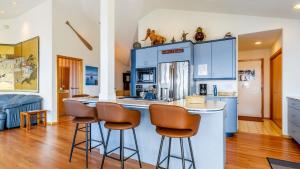 una cucina con armadi blu e sgabelli da bar di The Majestic Blue View by AvantStay Waterfront a Freeland
