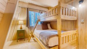 a bedroom with a bunk bed in a log cabin at Lundy Bearden Serene Tahoe Retreat with Deck Fireplace and Forest Views in Carnelian Bay