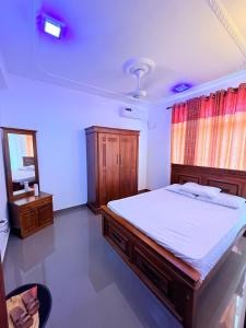 Un dormitorio con una cama grande y un espejo. en Canaan villa, en Dehiwala