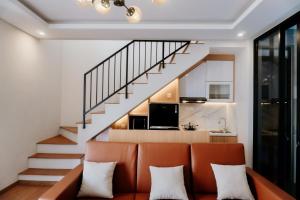 an orange couch in a living room with a staircase at Villa Caldera C6 Batu in Tlekung