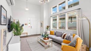 a living room with a gray couch and yellow chairs at Lealea by AvantStay Ocean Mountain Views in Waianae