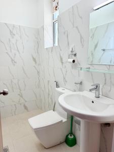 Un baño blanco con lavabo e inodoro. en Canaan villa, en Dehiwala