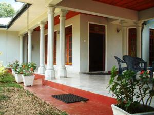 a front porch of a house with two chairs at Samanala Holiday Resort in Bandarawela +24 photos