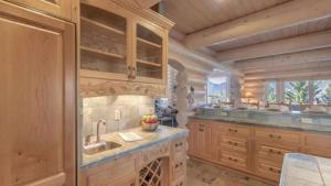 a large kitchen with wooden cabinets and a sink at Hot Tub Game Room Large Deck w Incredible View Penticton Lodge by AvantStay in Big Bear Lake +54 photos