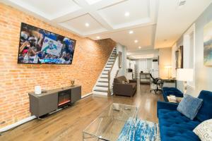 a living room with a couch and a brick wall at Downtown upper canton 3 bdrm 3 bath home with rooftop and parking pad in Baltimore