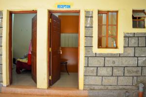 um quarto com duas portas abertas e uma parede de tijolos em Saboti Hotel em Mai Mahiu