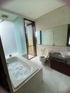 a bathroom with a tub and a toilet and a sink at Mai Villa Umalas in Canggu +4 photos