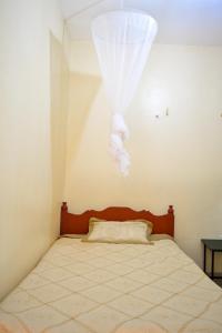 um quarto com uma cama com uma cortina branca em Saboti Hotel em Mai Mahiu