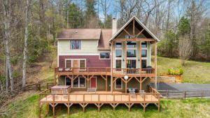 a large house with a large deck on a hill at Silver Spoon by AvantStay Hot Tub Views Billiards Group Retreat in Leicester