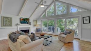 Una sala de estar con dos sofás y una chimenea. en 19 Oyster Row by AvantStay Lakefront Home w Golf Course Views, en Isle of Palms