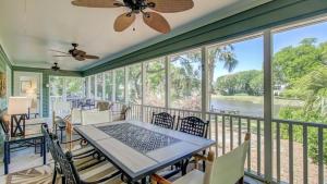 un porche cubierto con mesa y sillas en 19 Oyster Row by AvantStay Lakefront Home w Golf Course Views, en Isle of Palms