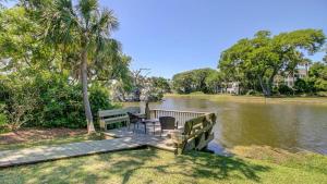 Un muelle con dos sillas y una mesa en el agua. en 19 Oyster Row by AvantStay Lakefront Home w Golf Course Views, en Isle of Palms