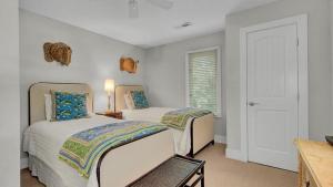 Un dormitorio con dos camas y una ventana. en 19 Oyster Row by AvantStay Lakefront Home w Golf Course Views, en Isle of Palms