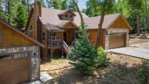 a wooden house with a garage and a tree at Teddy by AvantStay Majestic Cabin in Big Bear w Balcony in Big Bear Lake