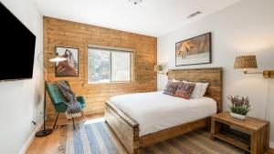 a bedroom with a bed in a room with wooden walls at Teddy by AvantStay Majestic Cabin in Big Bear w Balcony in Big Bear Lake