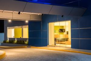 a building with a blue wall with a glass door at One Puebla Serdan in Puebla
