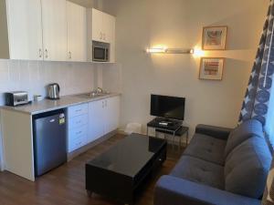 a living room with a couch and a kitchen at Ultimate Apartments Bondi Beach in Sydney