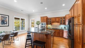 a kitchen with wooden cabinets and a table and chairs at Sunset Pointe by AvantStay Waterfront Beach Fire Pit Sleeps 14 5BDR 4BA in Terrell