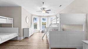 a bedroom with white bunk beds and a staircase at Sunset Pointe by AvantStay Waterfront Beach Fire Pit Sleeps 14 5BDR 4BA in Terrell