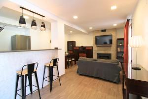 Una sala de estar con un sofá y un bar con sillas. en Apartamento Subida al Castillo II by SIERRA VIVA, en Aracena