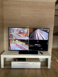 a flat screen tv sitting on a white tv stand at Paradise of Bogë Naturhaus in den Bergen von Peja in Peje