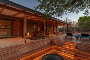 a wooden deck with a bench on a house at Nomads Den Safari Villas - Heated Pools and Riverbed views in Hoedspruit +79 photos