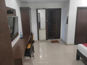 a room with a television and a room with two doors at Hotel Orion Inn in Tirupati