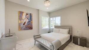 a bedroom with a bed and a painting on the wall at Villa Valentina by AvantStay Pool Hot Tub Views Luxury Design in Palm Springs +43 photos