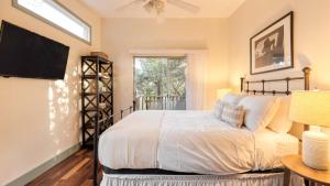 a bedroom with a bed and a tv and a window at Dawson by AvantStay Serene Austin Home set Amongst nature w Pool Close to Lake Travis in Austin +24 photos