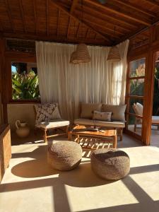 Una sala de estar con un sofá, una mesa y sillas. en JADA - New Quiet & Cozy House with Balinese Charm, en Bingin Beach