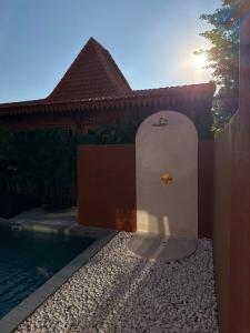 Una puerta a una casa con piscina al frente. en JADA - New Quiet & Cozy House with Balinese Charm, en Bingin Beach