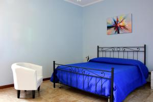 OtricoliにあるB&B Il Colleのベッドルーム(青いベッド1台、白い椅子付)