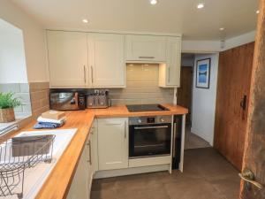 a kitchen with white cabinets and a counter top at Green Stile Cottage in Windermere