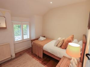 a small bedroom with a bed and a window at Green Stile Cottage in Windermere