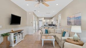 Una sala de estar con un sofá y un televisor. en Teal Dreams by AvantStay 3 blocks to Beach Back Patio Seating, en Santa Rosa Beach