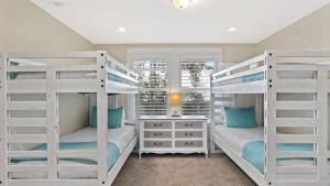 Dos literas blancas en una habitación con ventana. en Teal Dreams by AvantStay 3 blocks to Beach Back Patio Seating, en Santa Rosa Beach
