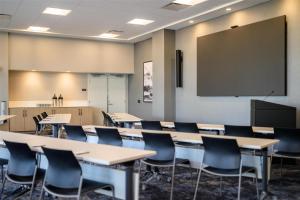 une salle de classe avec des tables et des chaises et un écran de projection dans l'établissement Hyatt Place Whitehorse, à Whitehorse
