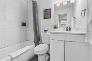 e bagno bianco con servizi igienici, vasca e lavandino. di Modern Midtown Stay Walk to Park & Dining ad Atlanta Altre 35 foto