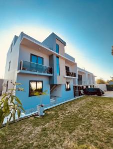 a blue and white house with a yard at Dee s Home in Dar es Salaam