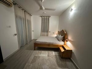 a small bedroom with a bed and a window at Dee s Home in Dar es Salaam