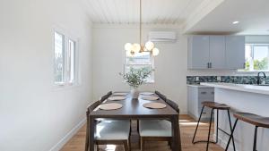 une cuisine blanche avec une table, des chaises et un comptoir dans l'établissement La Jolla Stay w Firepit Walk to Beach Arenas, à San Diego